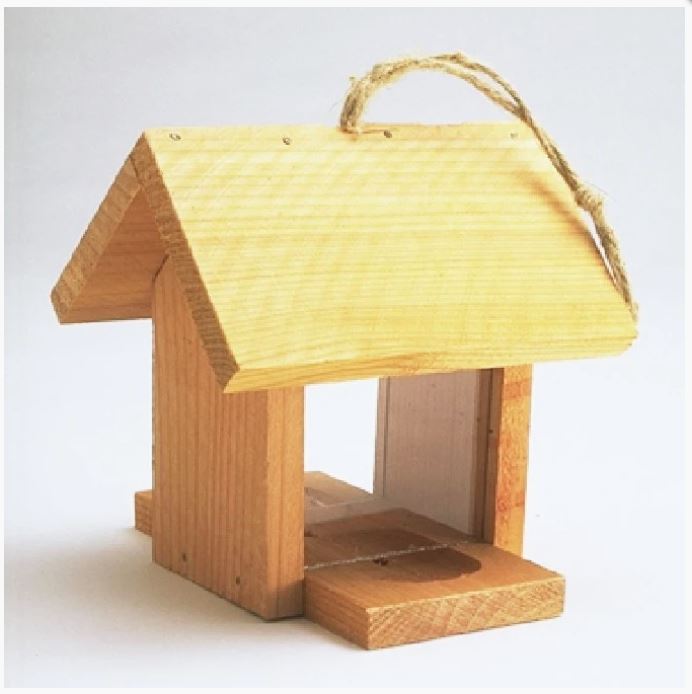 Small wooden bird feeder shaped like a house